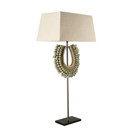 OKA The Samburu Lamp has a dramatic collar, with real cowrie shells and wooden beading in the design, closely resembling the jewellery worn in African tribes.