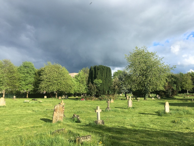 Graveyard with trees and dark clouds in the background