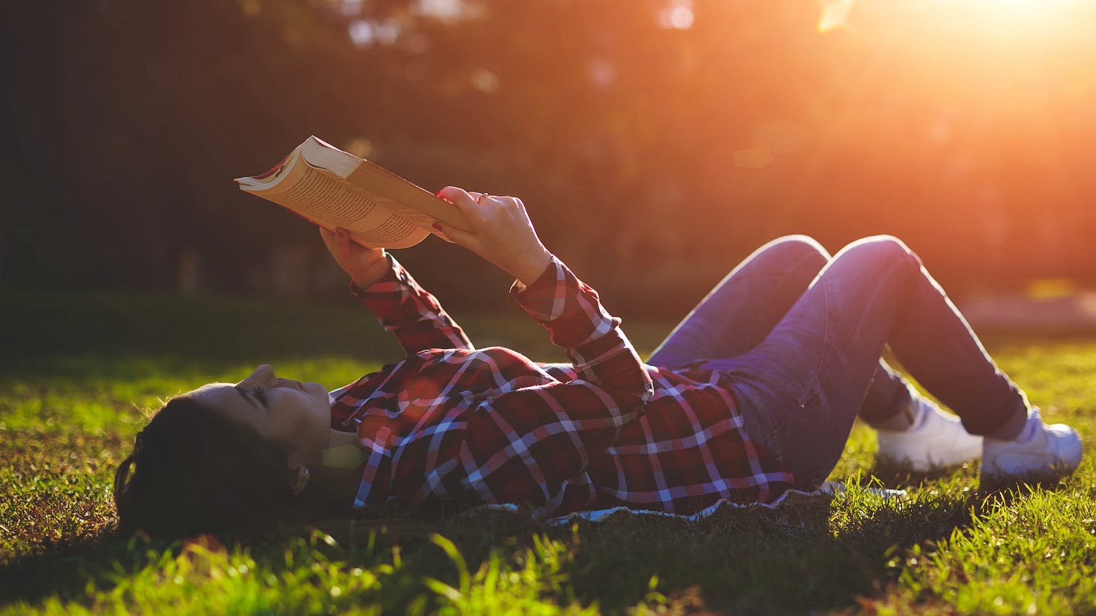 Bigstock-A-young-woman-lying-on-the-gra-81309563