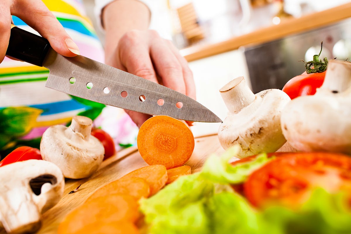 Bigstock-Woman-s-hands-cutting-carrot--32695808