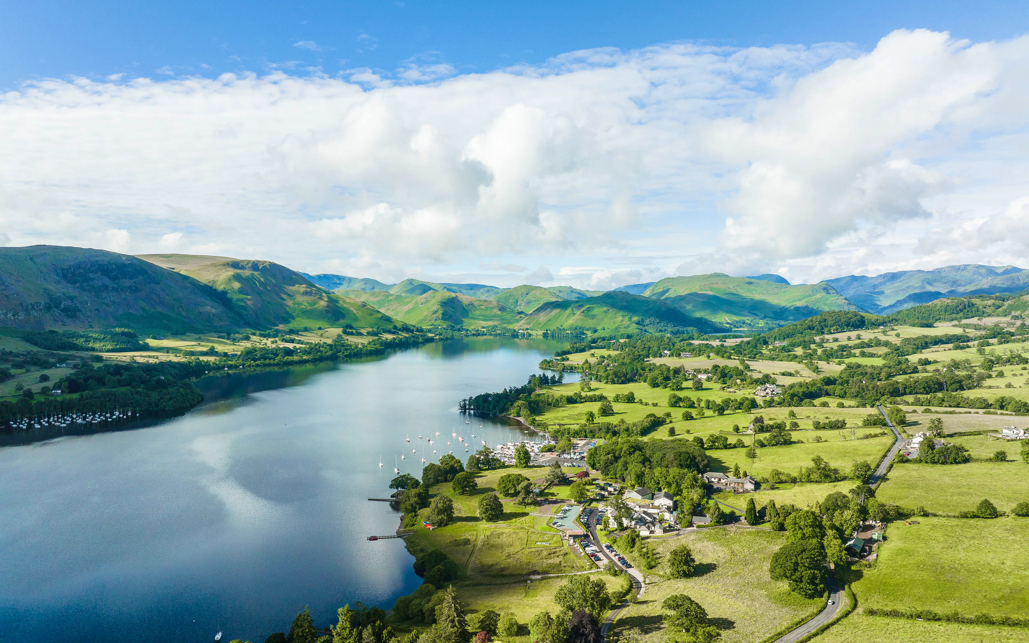 Aerial view of Ullswater in the Lake District, with green fells, farmland and the lakeside near Another Place