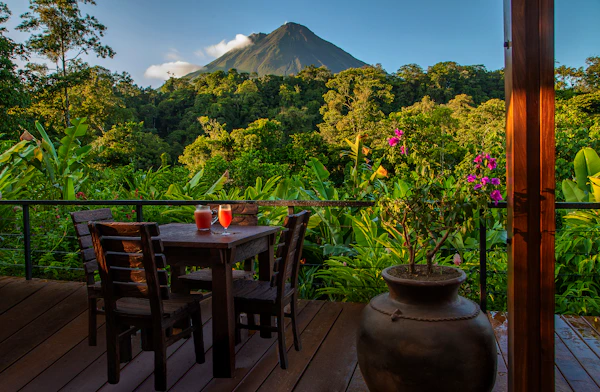 Balcony table with fruit drinks at Amor Arenal, overlooking rainforest and Arenal volcano in Costa Rica